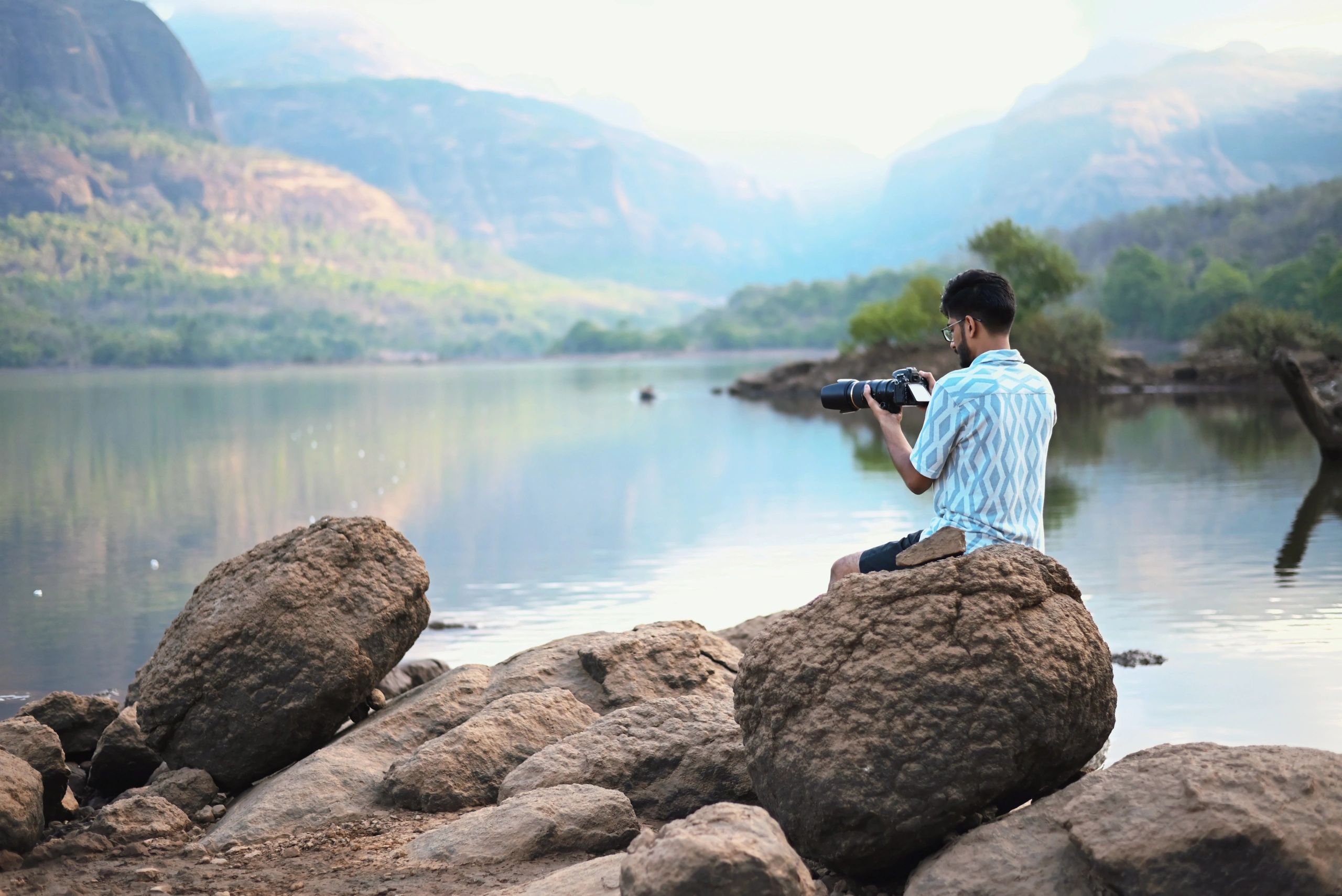 Photographer capturing scenery by a mountain lake