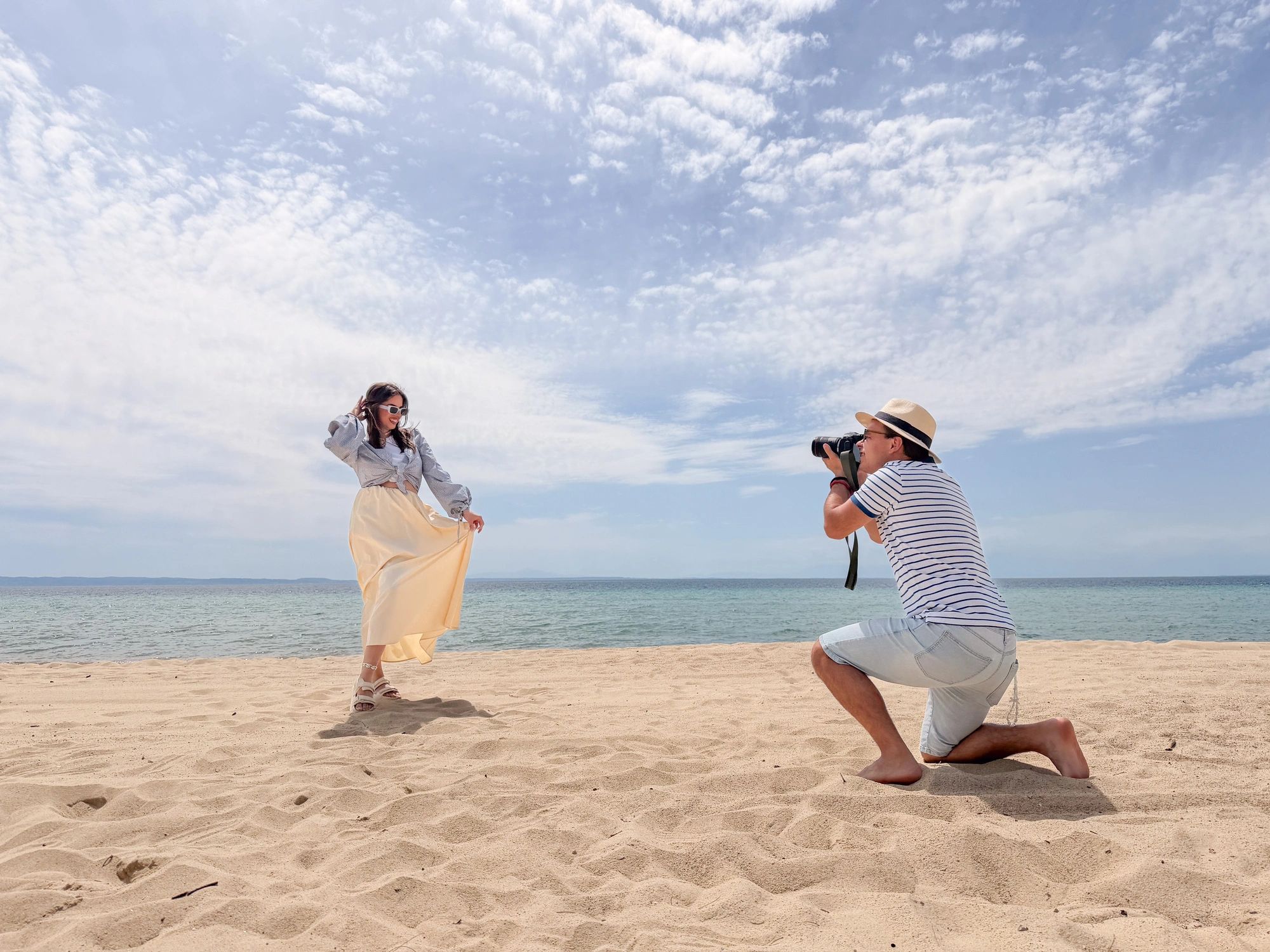 Photographer taking a portrait of a woman during a beach photoshoot